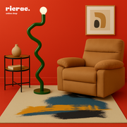 Modern interior featuring a metal lighting unit with a zigzag design beside a cozy armchair and artistic rug.