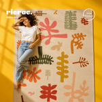 Ravelo- Printed Double Face Kilim on a colorful floor with a model showcasing its earthy tones and unique motifs.