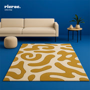 Razzo hand tufted rug with playful design in a modern living room setting against a blue backdrop.