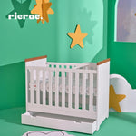 Ricalc baby cot bed displayed in a colorful nursery with stars, featuring a modern design and spacious drawer.