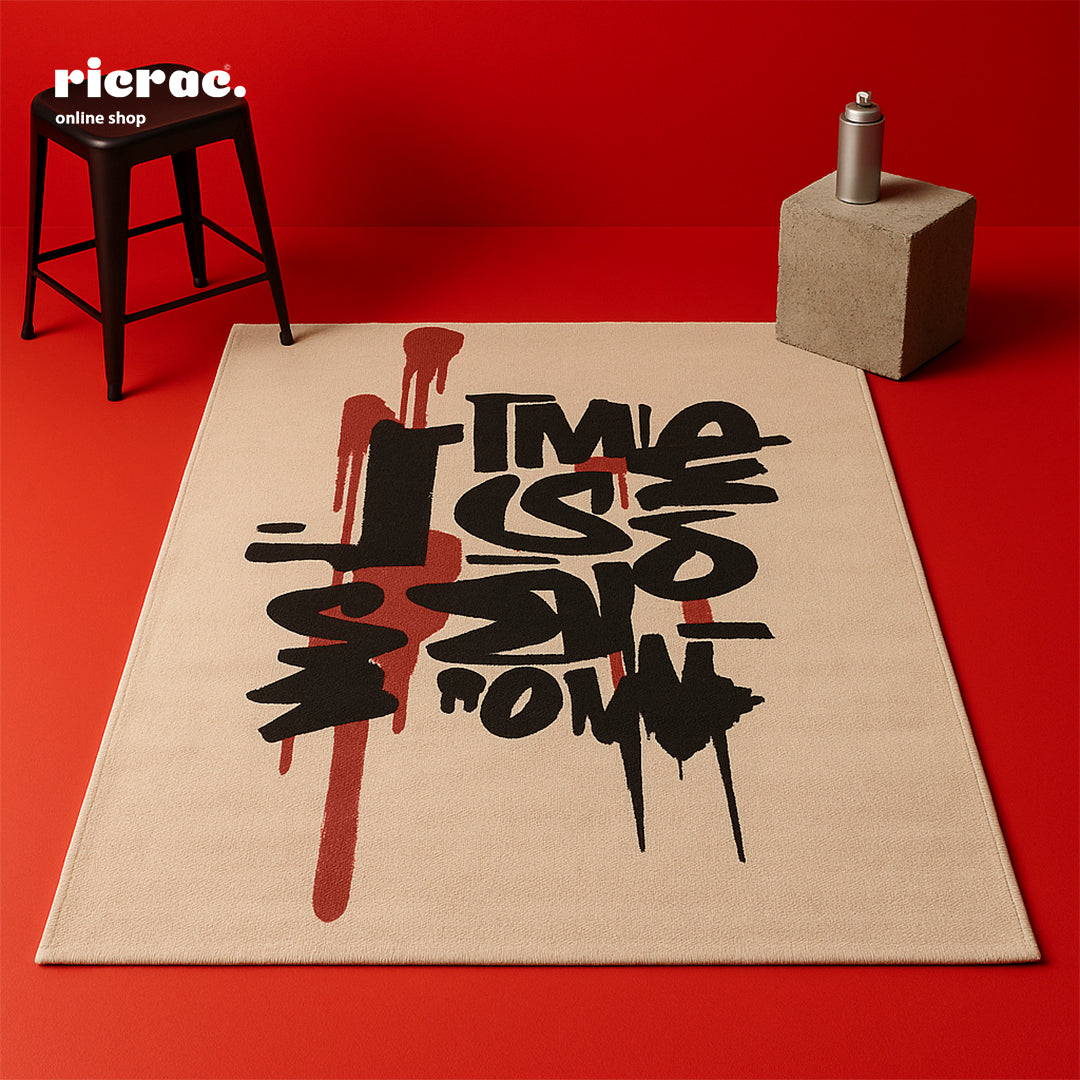 Riota- Printed Rug showcasing bold graffiti-style lettering on a soft background, perfect for modern creative spaces.