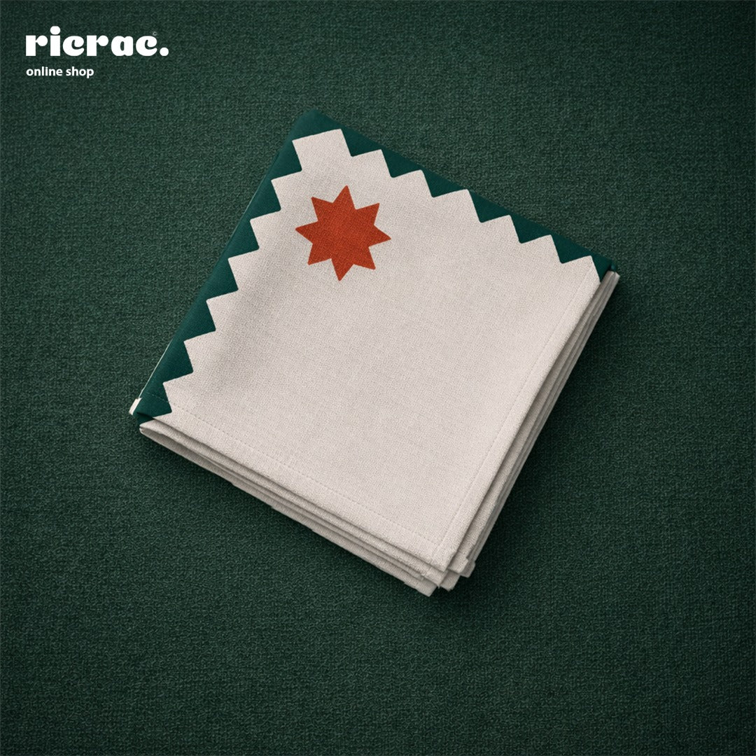 Waterproof cutlery napkins with orange star motifs, featuring a green zigzag border, neatly arranged on a table.