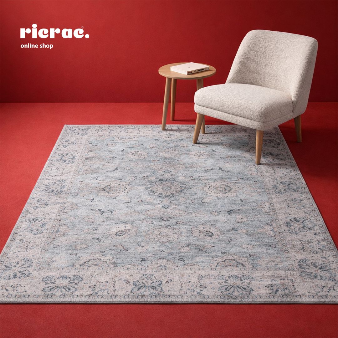 Chenille cotton Ganga rug displayed in a stylish living room setting with a chair and side table.