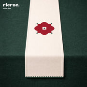 Waterproof Table Runner – Red Flower Motif with Green zigzag border displayed on a dark green table.