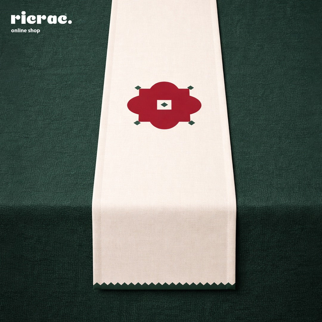 Waterproof Table Runner – Red Flower Motif with Green zigzag border displayed on a dark green table.