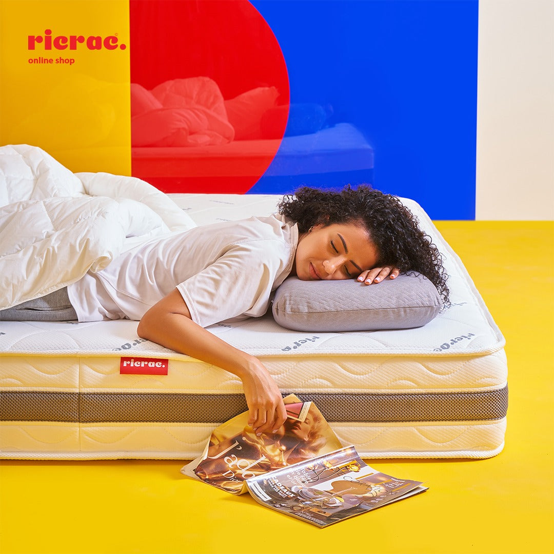 Couple sitting on a Zoning Mattress- RTS, demonstrating its firmness scale for optimal comfort and support.