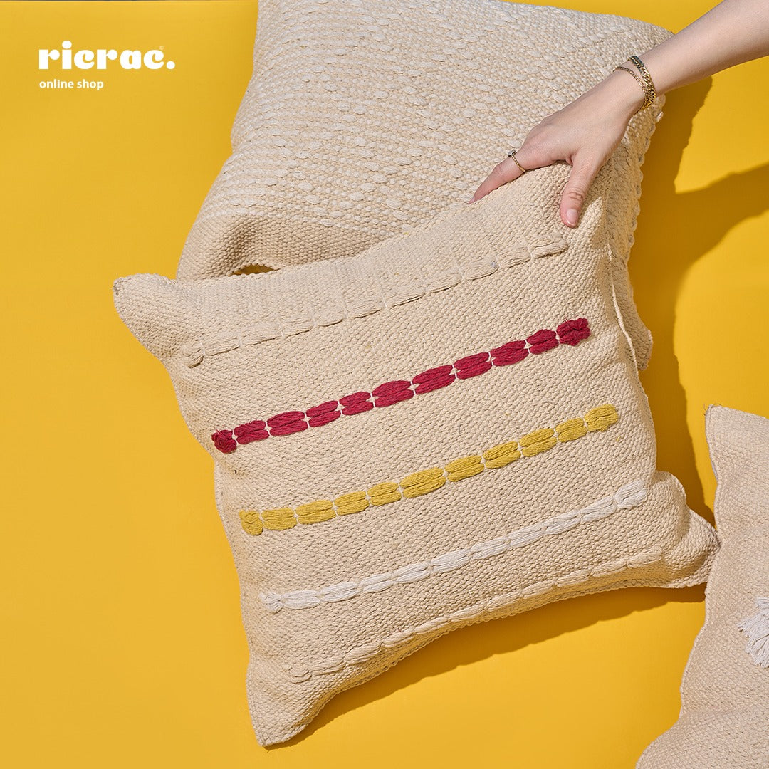 handcrafted kilim cushion in beige with red and yellow accents on a yellow background