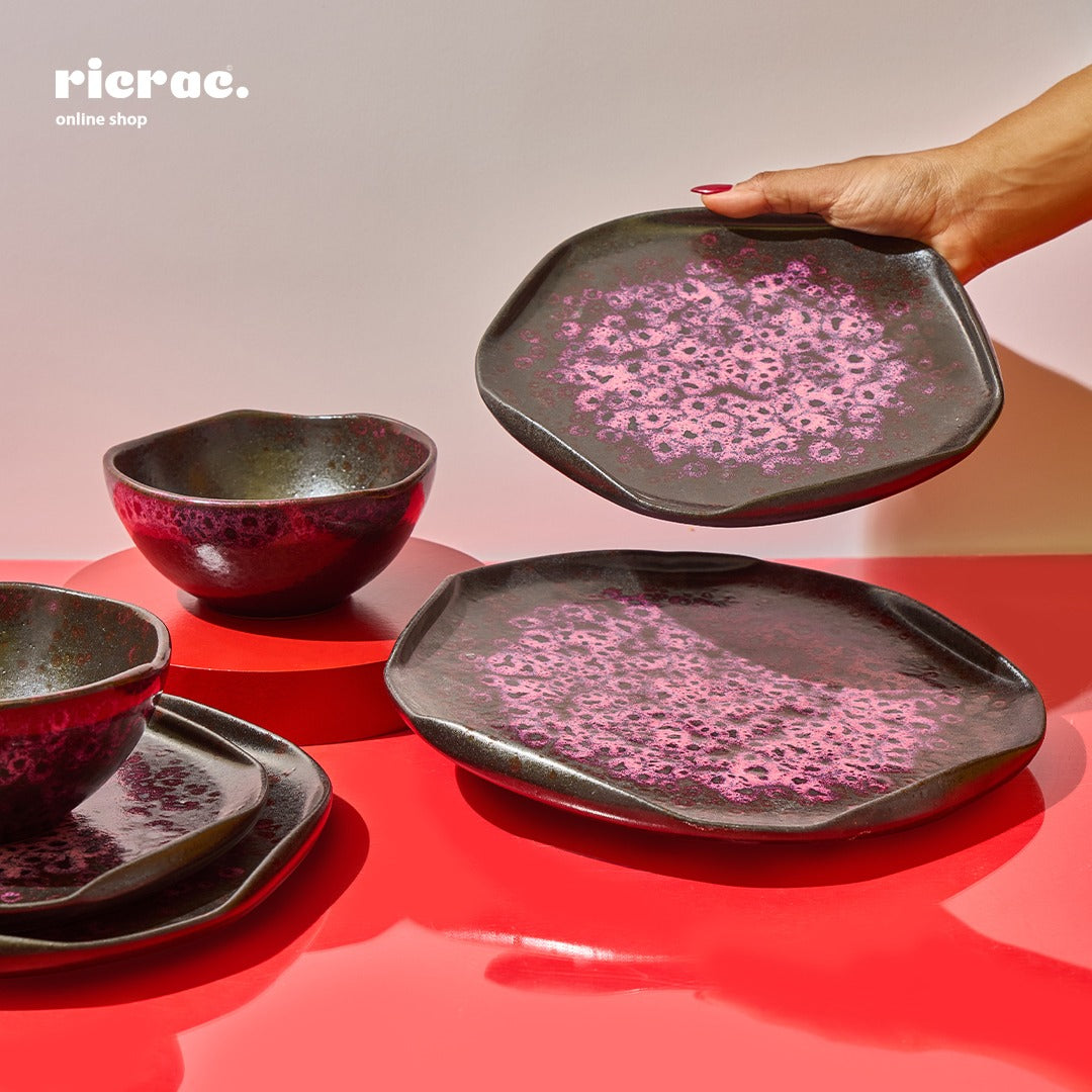 Handmade dinnerware set featuring three unique plates and bowls with a stylish pink and black speckled finish.