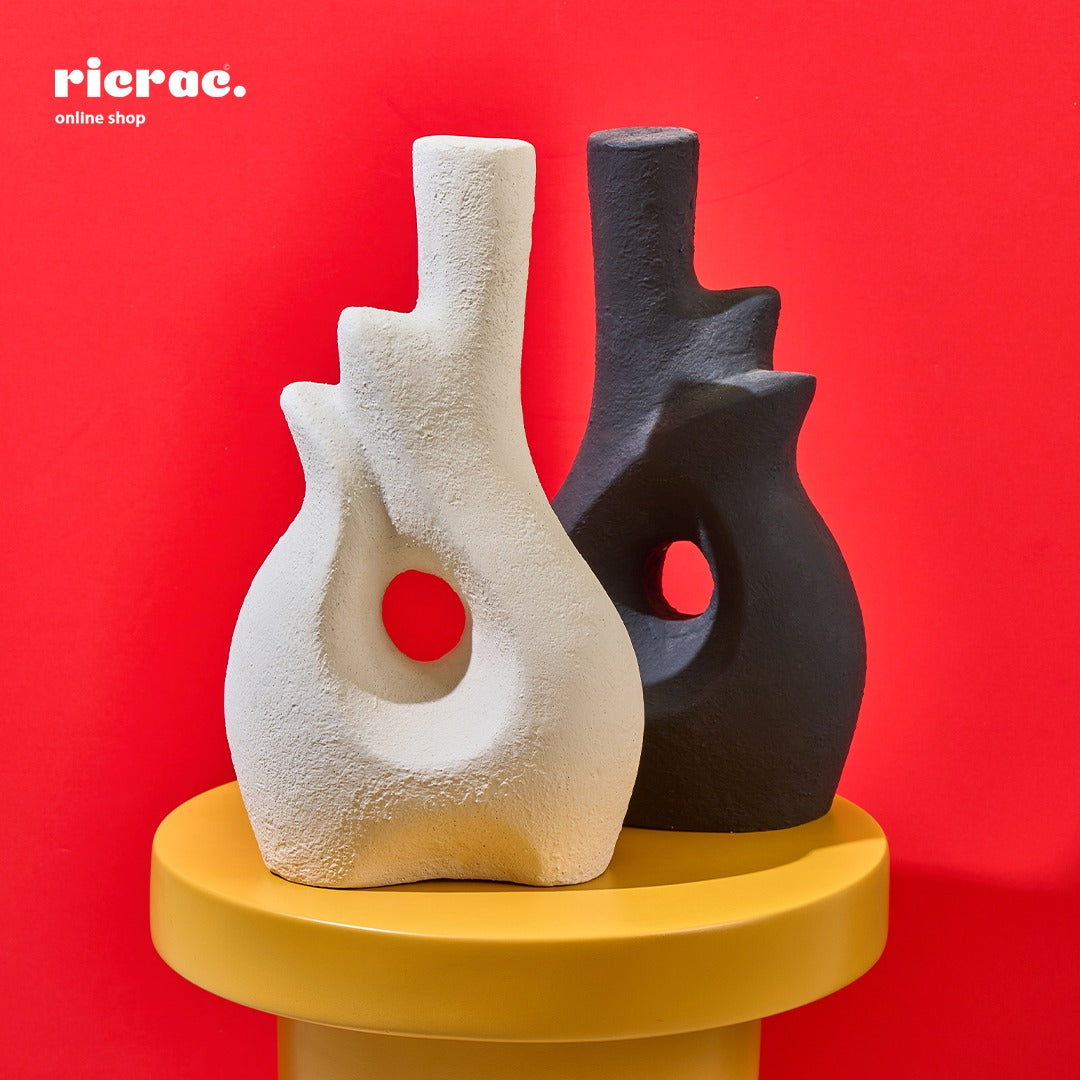 Rowa Accessory pottery vases in modern design, showcasing elegance on a yellow pedestal against a red background.