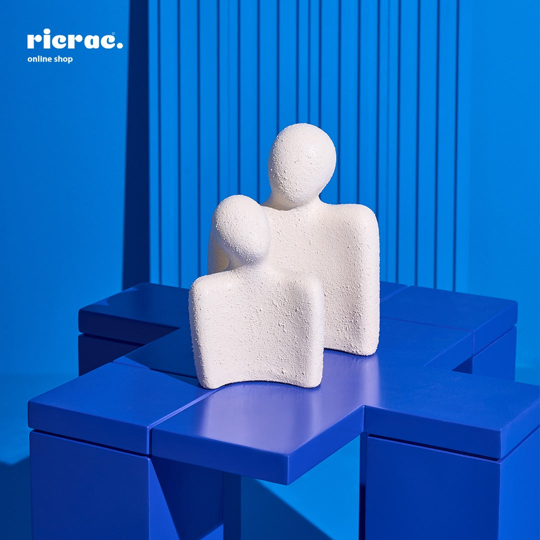 Handcrafted clay accessory figurines on a vibrant blue table, adding a stylish touch to home decor.