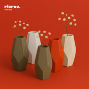 Remek- Geometric Clay Vase – Faceted Form in various colors with dried flowers on a red background
