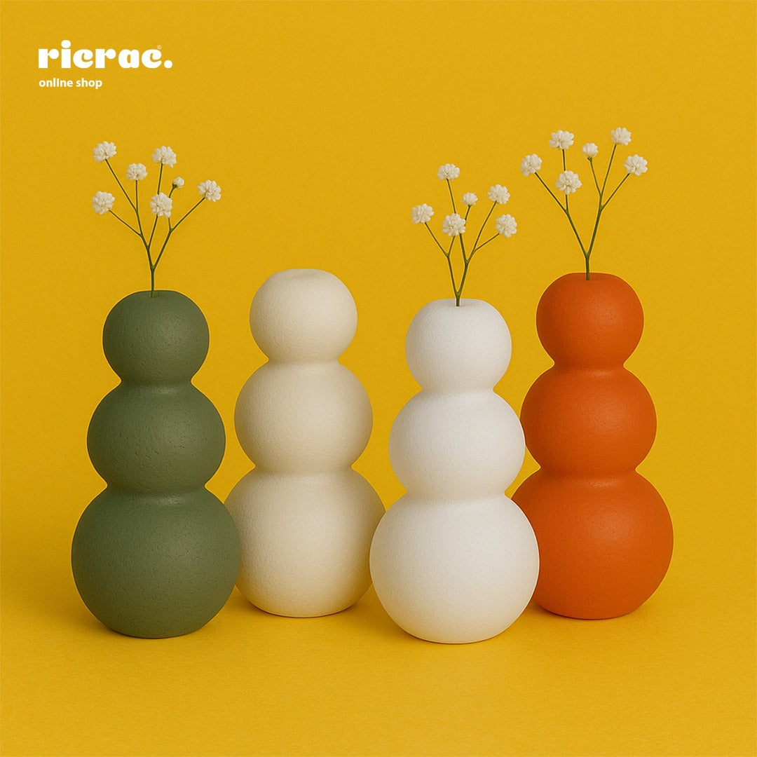 Sculptural Clay Vase in triple form curve design, featuring stacked round shapes in green, white, and orange against a yellow background.