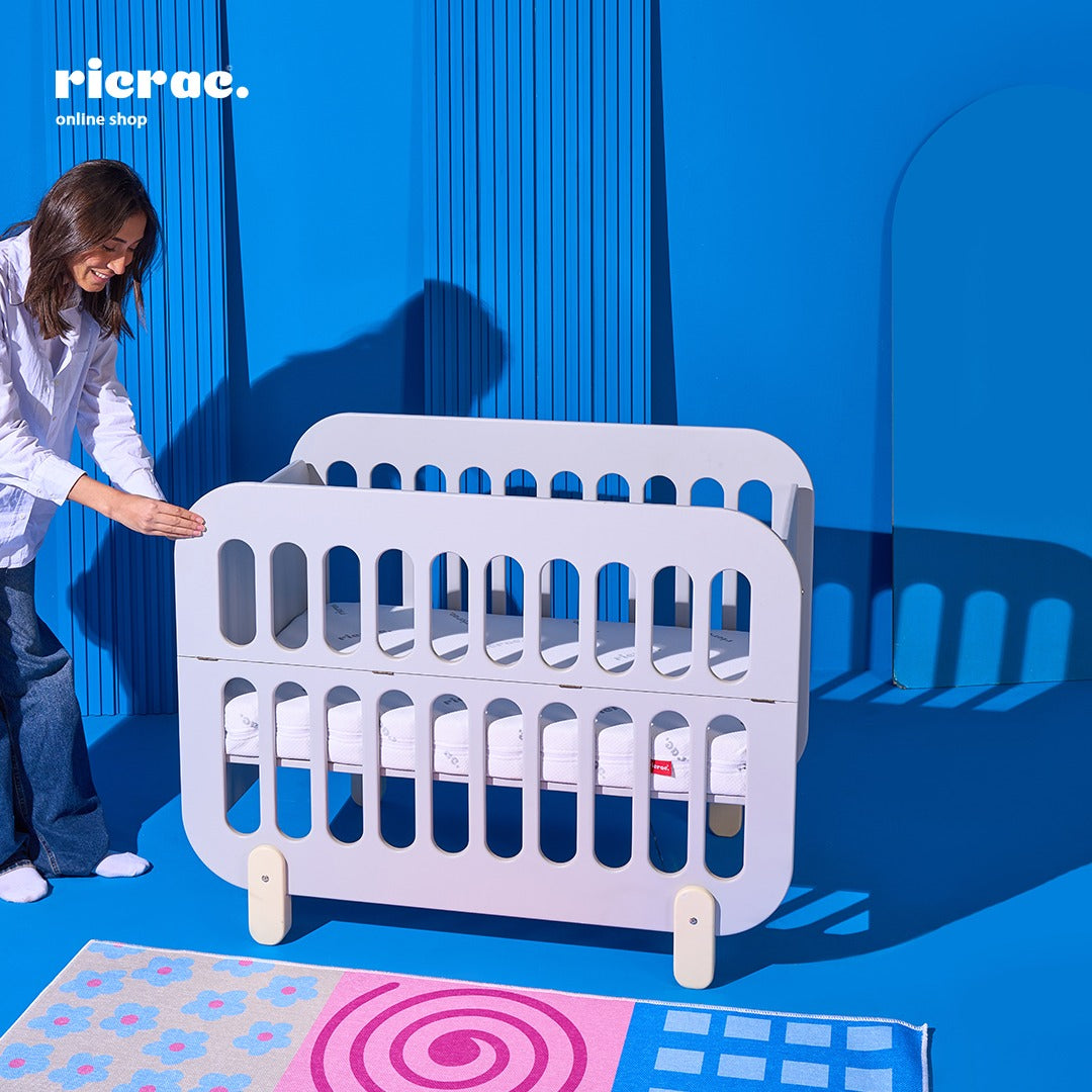 Refook- Baby Cot Bed with a side changing unit in a stylish nursery setting.