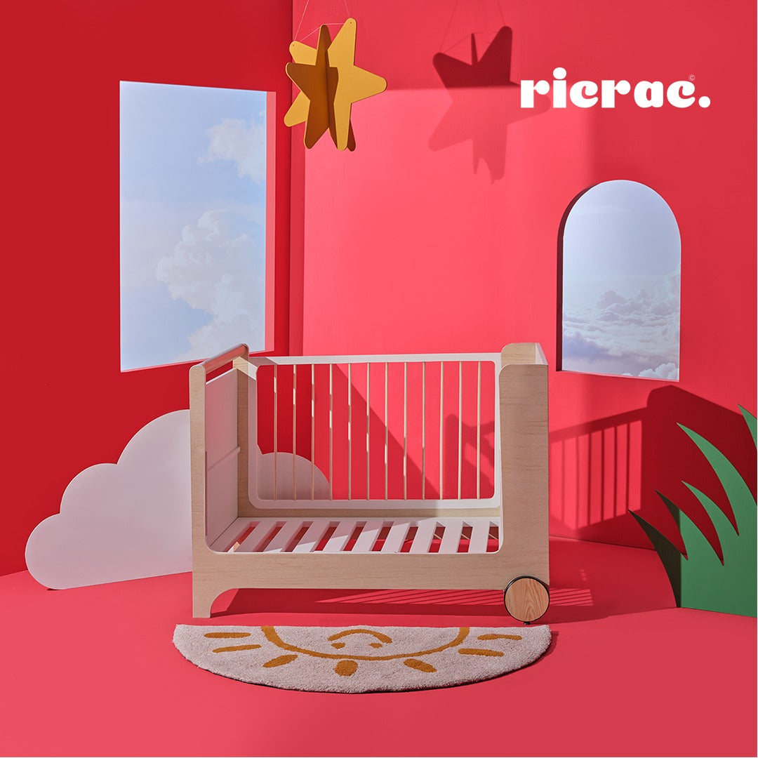 Rolata- Baby Cot Bed displayed in a colorful room with playful decorations, emphasizing its elegant design.