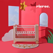 Rolata- Baby Cot Bed displayed in a colorful room with stars and cloud decorations.