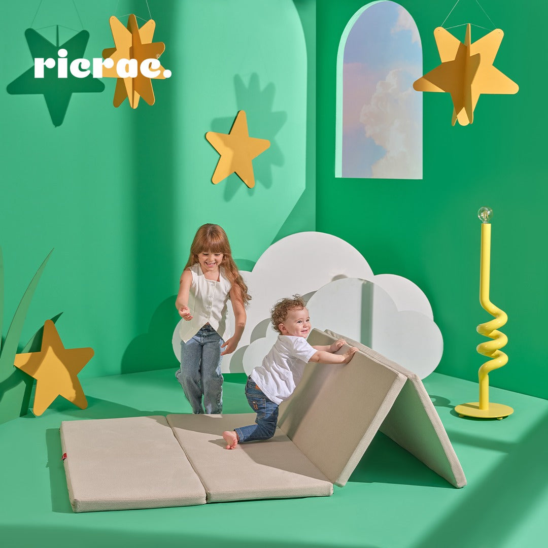Kids playing on the Rolata- Kids' Foldable Play Mat in a colorful room with stars and clouds.