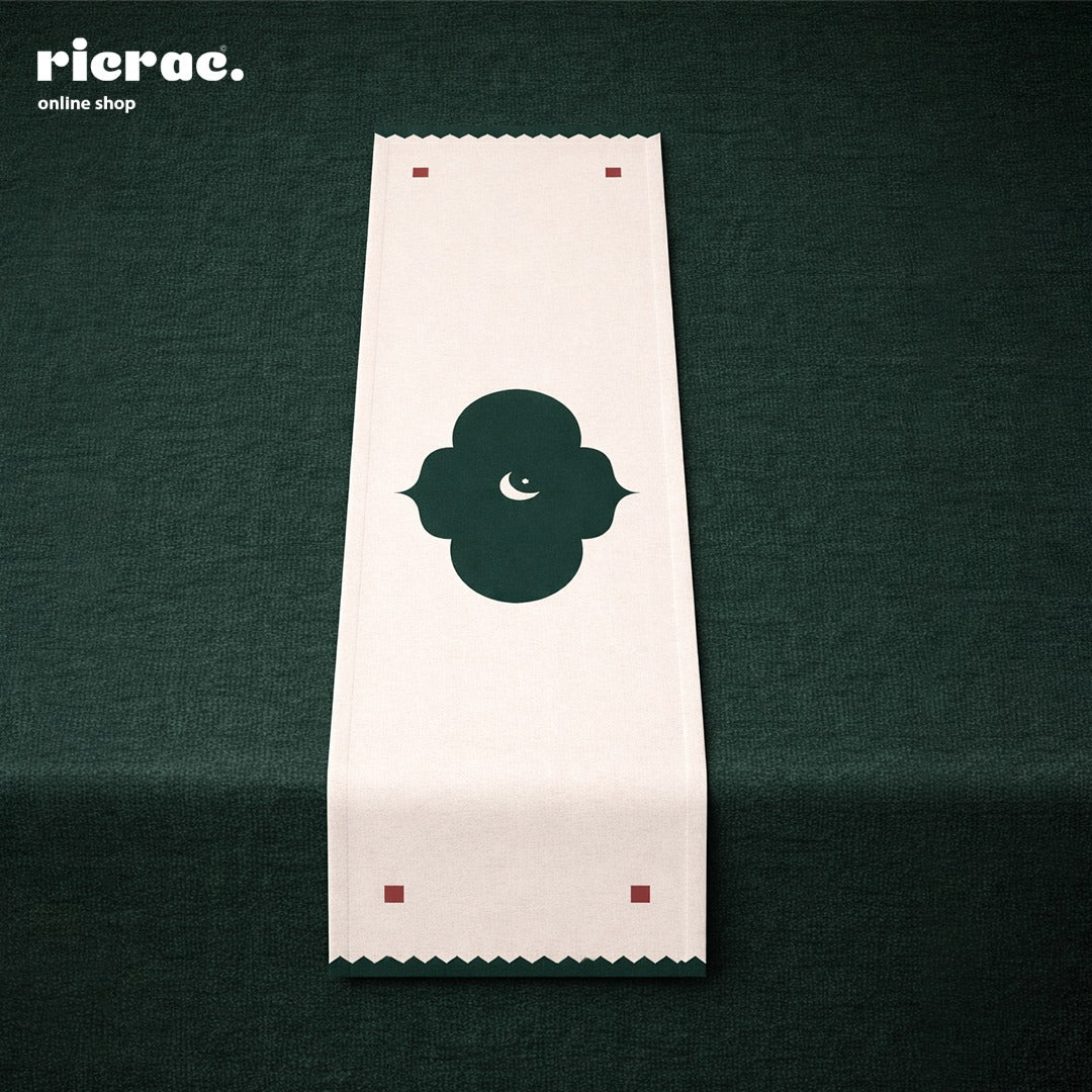 waterproof moroccan table runner featuring an elegant Islamic pattern on a dark green tablecloth.