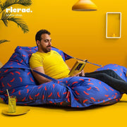 Man relaxing in a Buggle-up bean bag chair, reading a book in a bright yellow room, perfect for indoor and outdoor use.