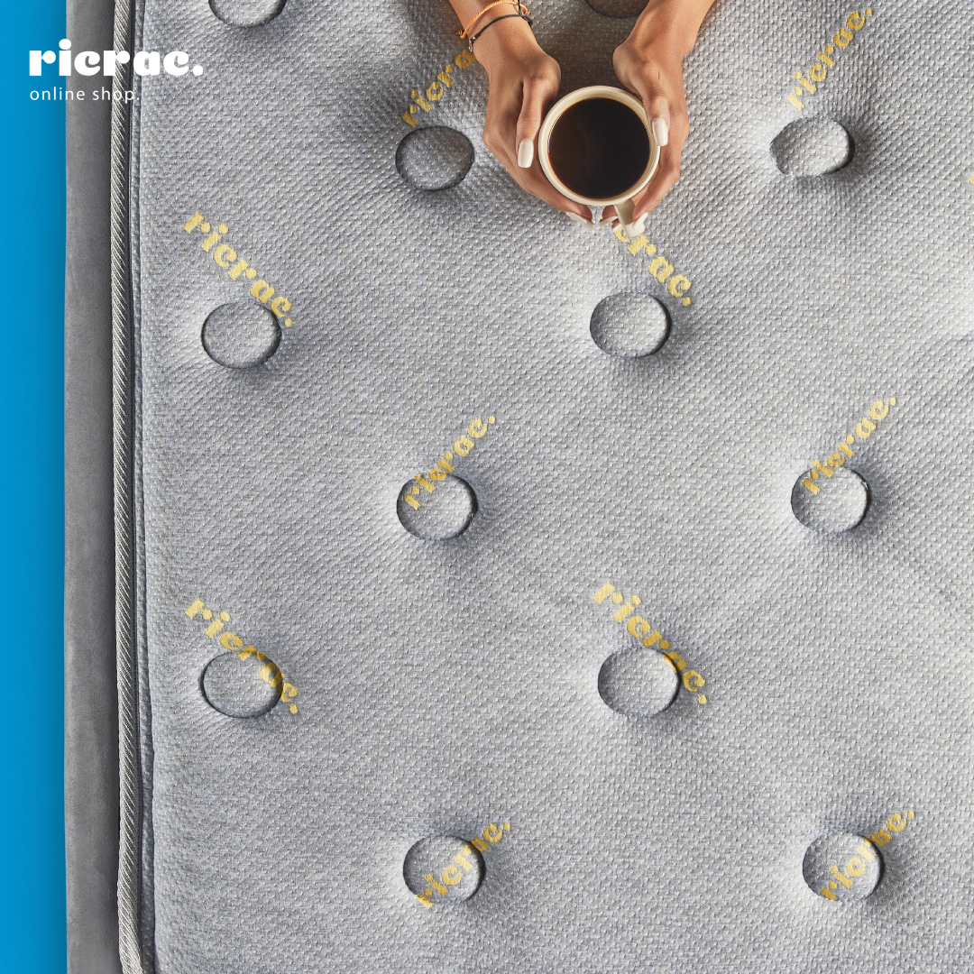 Natural Latex Mattress with Double Pocket Spring System- RTS with a hand holding a cup on its surface.